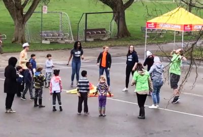 Group of campers and counselors singing around imaginary campfire at the fun fair