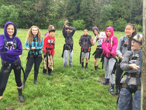 Group of campers smiling in rock climbing equipment